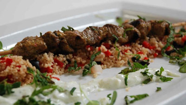 Grilled lamb kebabs with fresh tomato sauce on cous cous Grilled lamb kebabs with fresh tomato sauce on cous cous