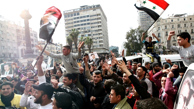 Damascus - Pro and anti-government supporters march in Syrian capital