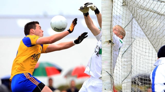 Leitrim goalkeeper Cathal McCrann punches the ball away under pressure from Roscommon's Donie Shine