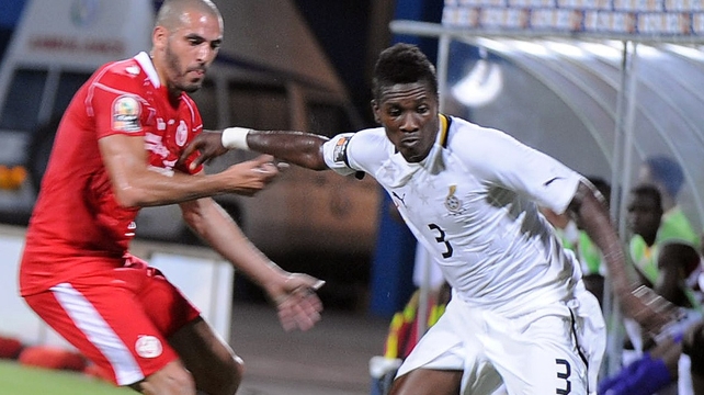 Ghana's Asamoah Gyan holds off Tunisia's Houcine Ragued in Sunday's quarter-final