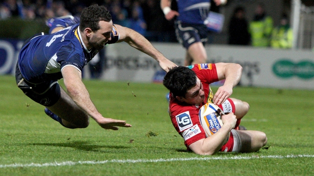 Scarlets Dan Newton touches down despite the best efforts of Leinster's David Kearney