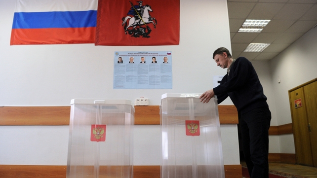 An election official adjusts a ballot box at a polling station in Moscow An election official adjusts a ballot box at a polling station in Moscow