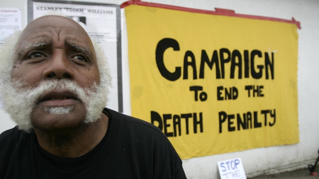 An anti-death penalty activists sits near a sign at the entrance of San Quentin State Prison in 2005 An anti-death penalty activists sits near a sign at the entrance of San Quentin State Prison in 2005