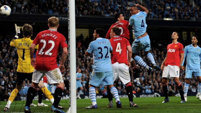 Vincent Kompany rises highest to power home a first-half header to give City victory in the Manchester derby