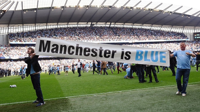 City fans celebrate on the pitch after their side clinched a first league title since 1968.