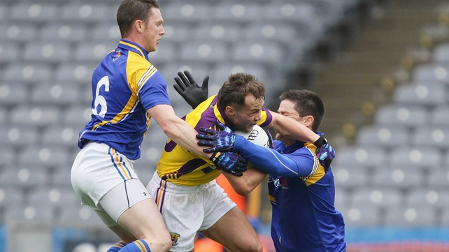 Wexford's Conor Carty is tackled by Mickey Quinn and Shane Mulligan of Longford