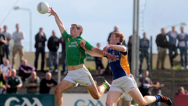 Shane Moran of Leitrim fields the ball under pressure from Wicklow's Peadar Burke
