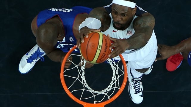 LeBron James scores despite the attention of France's Ali Traore