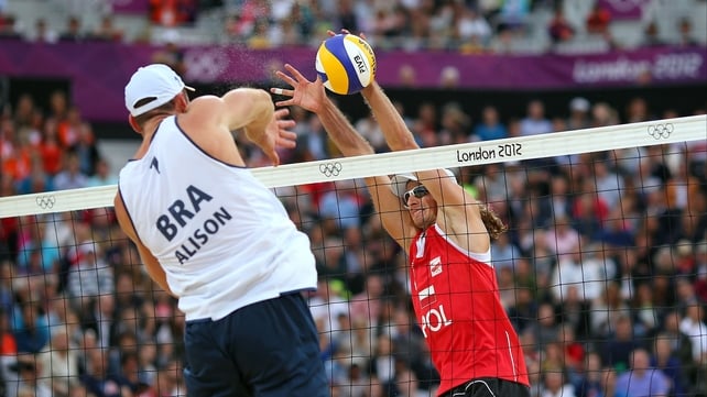 Alison Cerutti of Brazil hits a return against against Poland's Mariusz Prudel