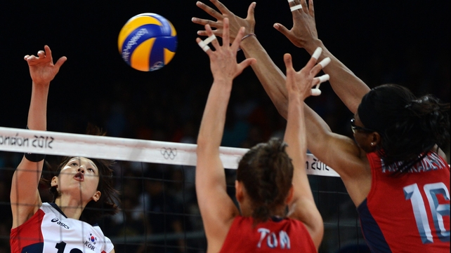 South Korea's Kim Yeon-Koung (L) spikes as Logan Tom (C) and Foluke Akinradewo of the US attempt to block