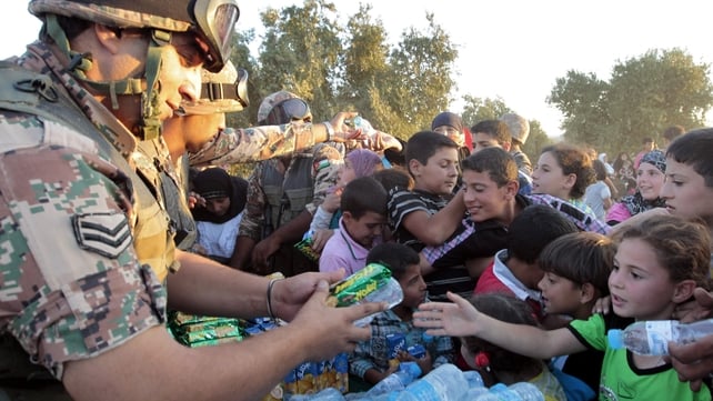 Jordanian soldiers distribute water and snacks to newly-arrived Syrian refugees after they crossed the border into Jordan Jordanian soldiers distribute water and snacks to newly-arrived Syrian refugees after they crossed the border into Jordan