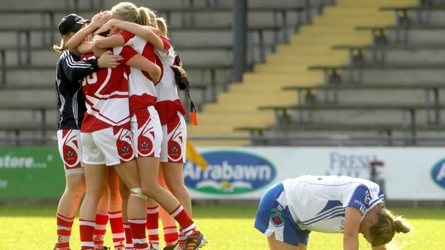Cork players celebrate the final whistle as Ellen McCarron of Monaghan drops to the ground