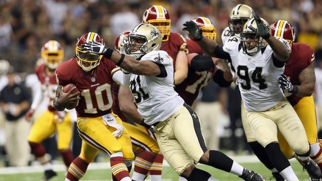 Robert Griffin III escapes the attentions of Will Smith of the New Orleans Saints