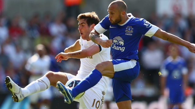 Danny Graham of Swansea City is challenged by Everton's John Heitinga