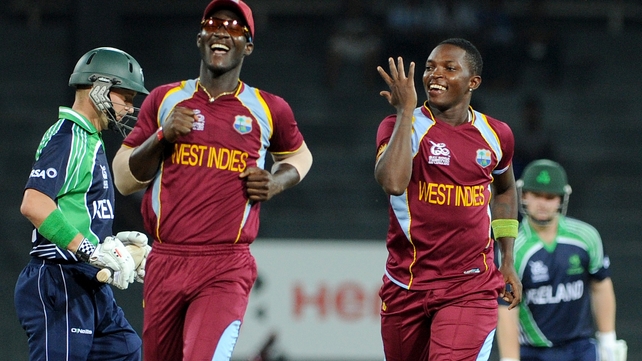 William Porterfield walks away after being bowled first ball by Fidel Edwards (right). Fellow Windies bowler Darren Sammy joins in the celebrations