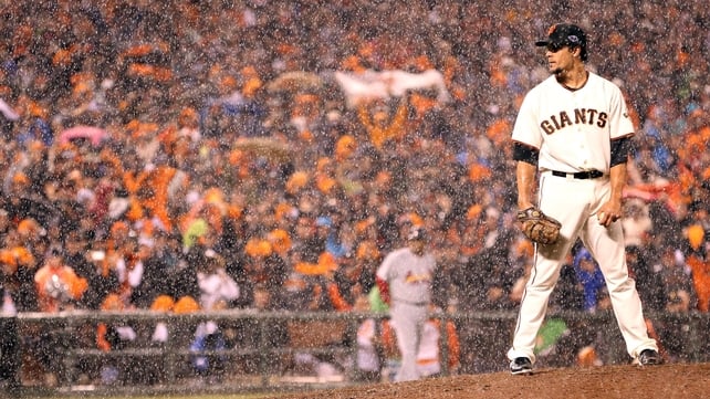 Javier Lopez of the San Francisco Giants pitches in the rain towards the end of the ninth inning