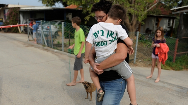 An Israeli mother carries her child following a rocket attack from Gaza An Israeli mother carries her child following a rocket attack from Gaza