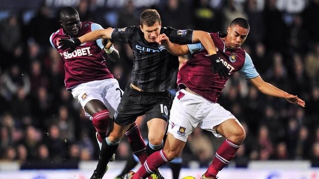 Manchester City striker Edin Dzeko is sandwiched between West Ham's Winston Reid (r) and Mohamed Diame