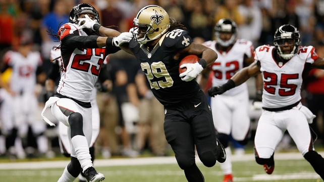 Chris Ivory of the New Orleans Saints hands off Dunta Robinson of the Atlanta Falcons to score a touchdown at the Mercedes-Benz Superdome
