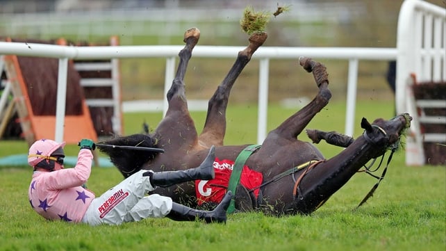 Paul Carberry slides clear of the rolling Go Native after their fall at the last hurdle in the Morgiana Hurdle