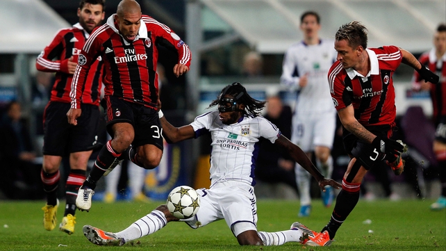 Dieudonne Mbokani of Anderlecht tackles Nigel De Jong of AC Milan