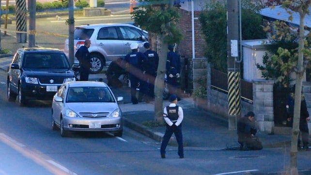 Japanese policemen erect a cordon near the bank where a man is holding hostages in Toyokawa city Japanese policemen erect a cordon near the bank where a man is holding hostages in Toyokawa city