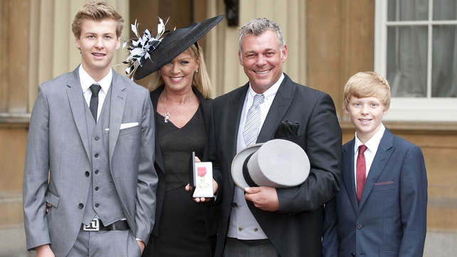 Darren Clarke and his family pose with his badge after receiving an OBE from the Queen