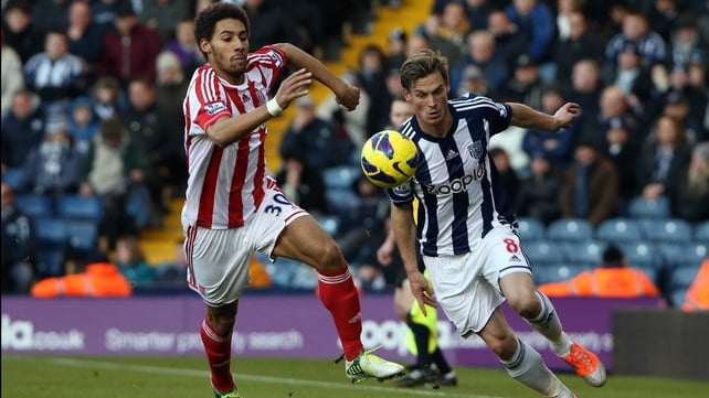 Markus Rosenberg (R) of WBA and Stoke's Ryan Shotton go in chase