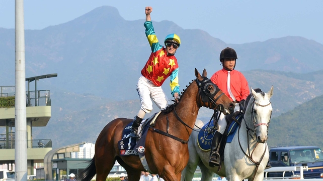 Zac Purton punches the air after steering Ambitious Dragon to victory in the Hong Kong Mile at Sha Tin
