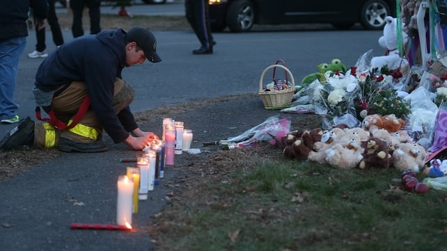 A firefighter kneels at a makeshift memorial near Sandy Hook Elementary School A firefighter kneels at a makeshift memorial near Sandy Hook Elementary School