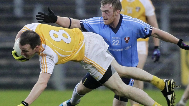Gregory McGovern of UUJ (r) puts pressure on Antrim's Michael McCann