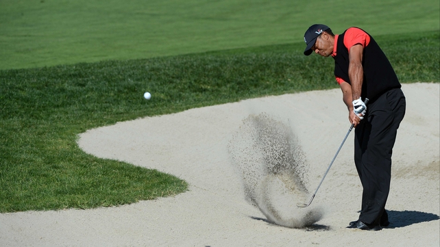 Tiger Woods plays out of the bunker on the 10th
