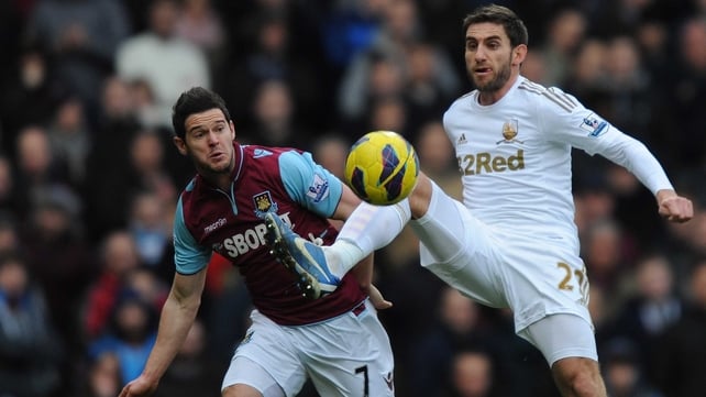 Angel Rangel of Swansea City holds off the challenge of West Ham's Matt Jarvis