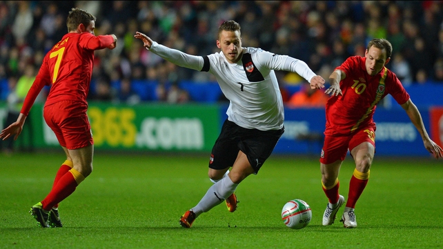 Marko Arnautovic vies with Wales midfielders David Vaughan (R) and Joe Allen (L)
