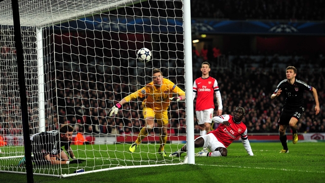 Wojciech Szczesny of Arsenal scrambles in vain to prevent the ball crossing the line as goalscorer Mario Mandzukic of Bayern Munich watches from inside the goal