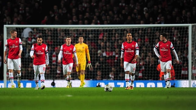 Dejected Arsenal players return to the centre circle following a Bayern goal