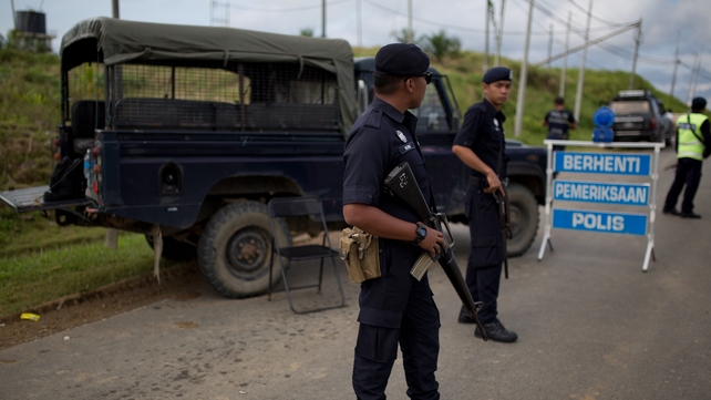 Malaysian police man a security checkpoint in Cenderawasih, Borneo Malaysian police man a security checkpoint in Cenderawasih, Borneo
