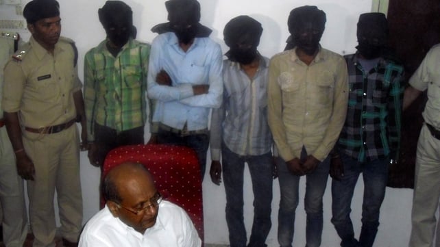 Indian Deputy Inspector General DK Arya (C) sits in front of five hooded suspects during a press meeting in Datia Indian Deputy Inspector General DK Arya (C) sits in front of five hooded suspects during a press meeting in Datia