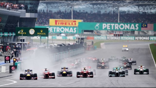 Sebastian Vettel (l) leads the field into turn one of the Malaysian Formula One Grand Prix at the Sepang Circuit