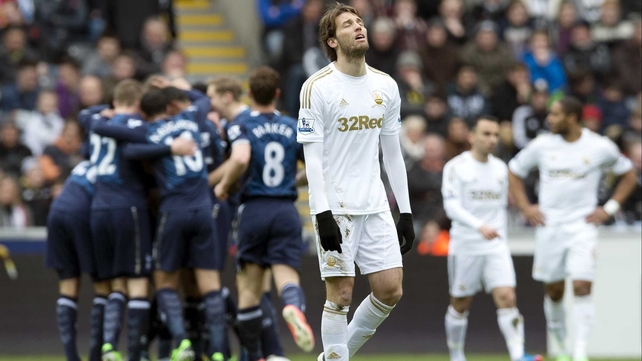 Miguel Michu reacts as Spurs players celebrate a goal