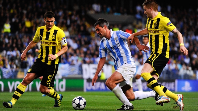 Jeremy Toulalan of Malaga CF duels for the ball with Sebastian Kehl (L) and Marco Reus