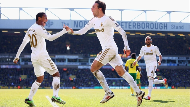 Swansea's Spanish striker Michu is congratulated by team-mate Jonathan de Guzman
