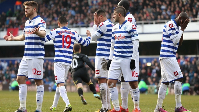 Shaun Maloney runs away in celebration as the QPR players take in Wigan's last-minute equaliser