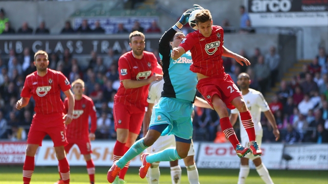 Swansea 'keeper Michel Vorm collects despite the efforts of Adam Lallana