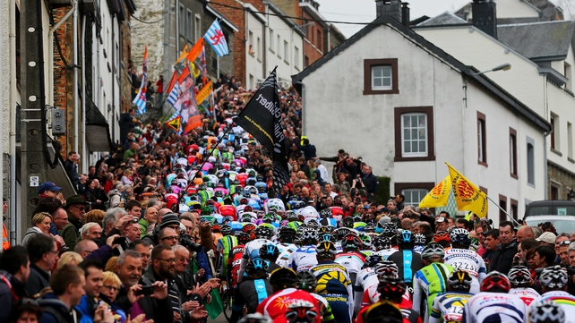 Crowds of people watch as the peloton climbs the Cote de Saint-Roch