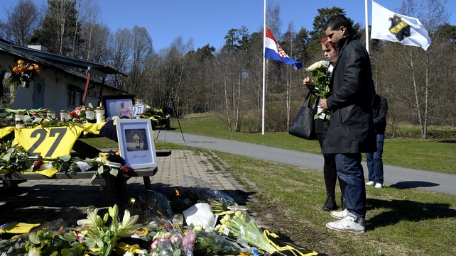 Fans gathered to lay scarves and flowers at an impromptu shrine