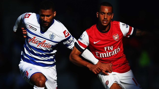 Armand Traore (L) of Queens Park Rangers holds off the challenge of Theo Walcott