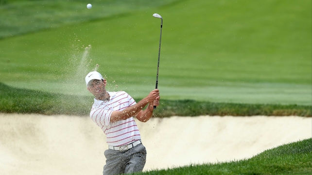 2011 Masters champion Charl Schwartzel plays from the bunker on the first hole