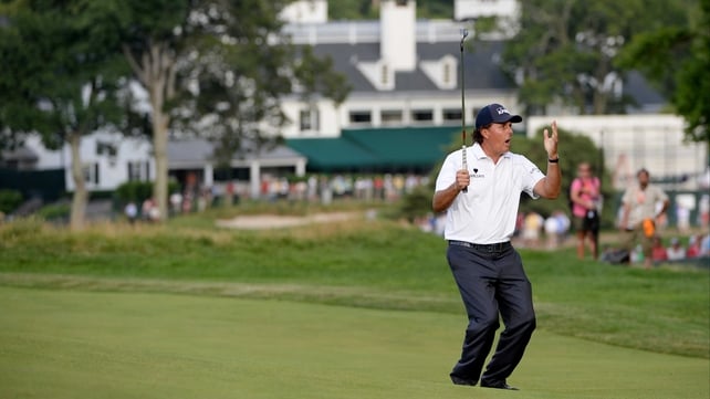 Mickelson watches his putt roll to the hole