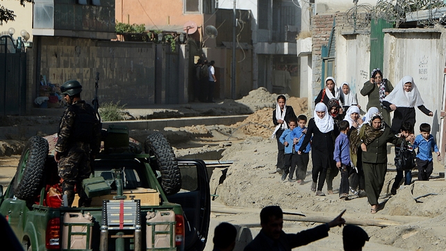 Afghan security forces keep watch as schoolgirls walk near the entrance gate of the presidential palace in the aftermath of attack Afghan security forces keep watch as schoolgirls walk near the entrance gate of the presidential palace in the aftermath of attack